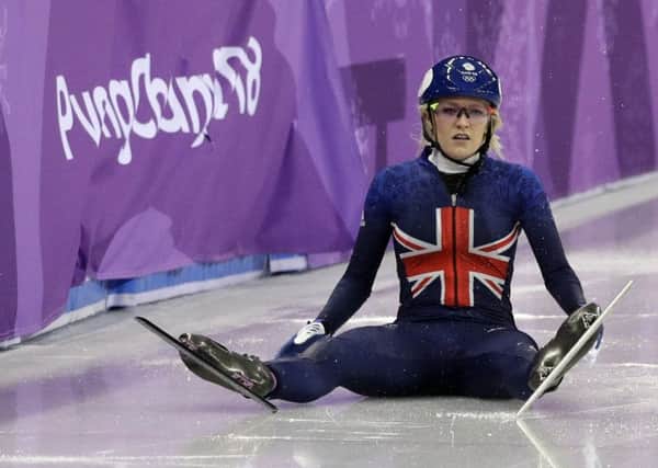 Elise Christie of Britain sits on the ice after crashing during the ladies' 500 metres short track speedskating final.