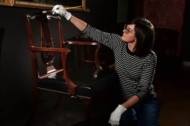 Ruth Martin, Leeds City Museums curator of special exhibitions, cleans a 1768 mahogany chair by Thomas Chippendale