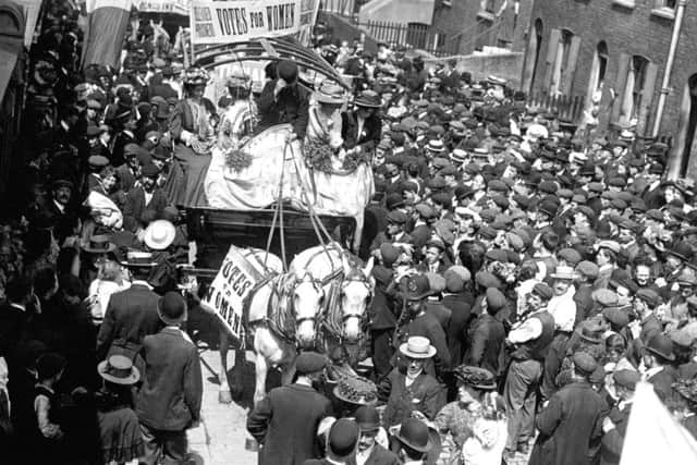 Crowds line the streets as they watch suffragettes (left to right) Emmeline Pankhurst, Mary Jane Clark (Emmeline's sister), the driver, Charlotte Marsh and Jessie Kelly pass by following their release from Holloway Prison in 1908. (PA)