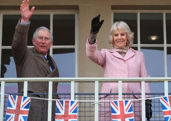The Prince of Wales and Duchess of Cornwall wave to the crowds from the balcony of Halifax's Piece Hall.