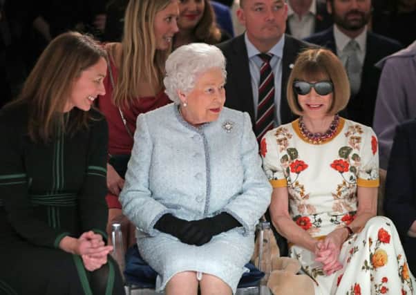 ALL SMILES NOW: Queen Elizabeth II sits next to Anna Wintour (right) and Caroline Rush, chief executive of the British Fashion Council (BFC) (left) as they view Richard Quinn's runway show before presenting him with the inaugural Queen Elizabeth II Award for British Design as she visits London Fashion Week's BFC Show Space in central London. Yui Mok/PA Wire