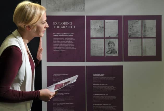 3D designer Harriet Whitehead inspects the display boards produced by Leach in Huddersfield for the community exhibition showing the graffiti at Richmond Castle in North Yorkshire. .Picture by Tony Johnson.