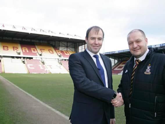 Dave Aveyard, operations director at Christeyns and Bradford City FC commercial manager Michael Shackleton on the pitch at Valley Parade.