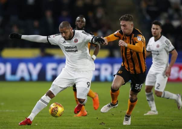 Leon Clarke of Sheffield Utd is tackled by Hull City's Angus MacDonald is the KCOM Stadium. Picture: Simon Bellis/Sportimage