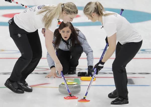 Britain's skip Eve Muirhead, center, throws a stone as teammates Lauren Gray, left, and Vicki Adams sweep the ice during a women's curling match against Canada at the 2018 Winter Olympics in Gangneung, South Korea, Wednesday, Feb. 21, 2018. (AP Photo/Natacha Pisarenko)