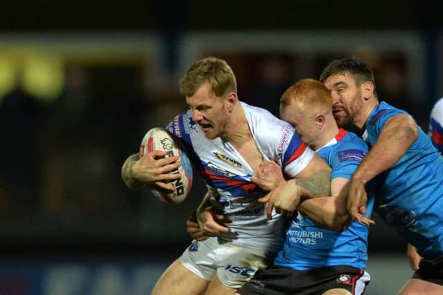 Tom Johnstone tangles with Salford's Josh Wood.  Picture: Bruce Rollinson