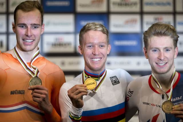 Gold medalist Cameron Meyer of Australia, center, silver medalist Jan Willem van Schip of The Netherlands, left, and bronze medalist Mark Stewart of Britain celebrate on the podium after the men's points race at the World Championships.