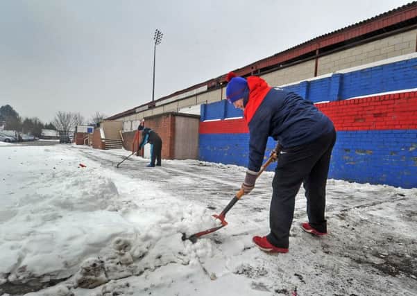 Wakefield Trinity's dedicated fans clear the area surrounding the Trinity Mobile Rocket Stadium in an effort to stage Sunday's game with the Huddersfield Giants.  Pictures Tony Johnson.