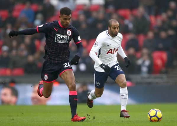Battling: Huddersfield Town's Steve Mounie, left, and Tottenham Hotspur's Rodrigues Lucas Moura fight for possession.