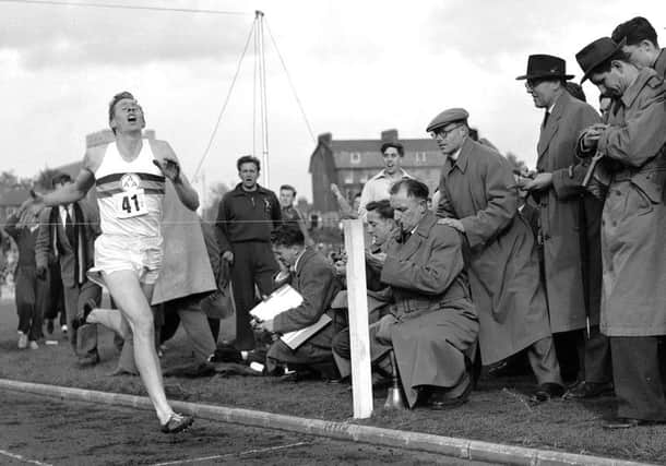 1954: Britain's Roger Bannister hits the tape to become the first person to break the four-minute mile