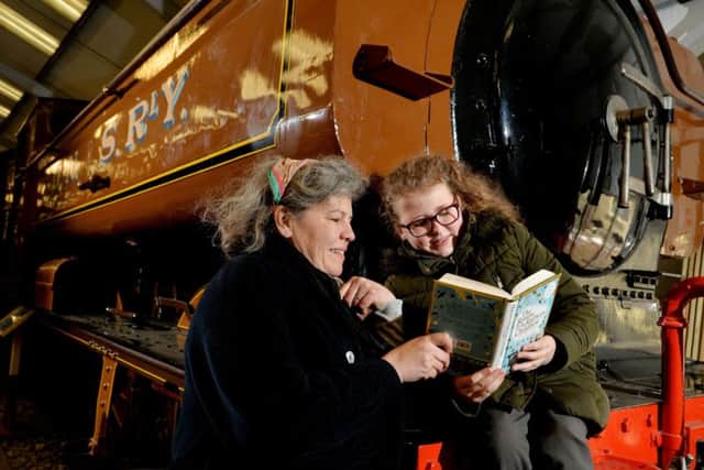 Chloe Goodall, 9, from Worth Valley Junior School, reading The Return of the Railway Children with author Lou Kuenzler, a magical sequel to the perennial classic tale of The Railway Children. Chloe is sat on the original pannier tank used in the film in the engine shed at Oxenhope Station.  Picture Bruce Rollinson