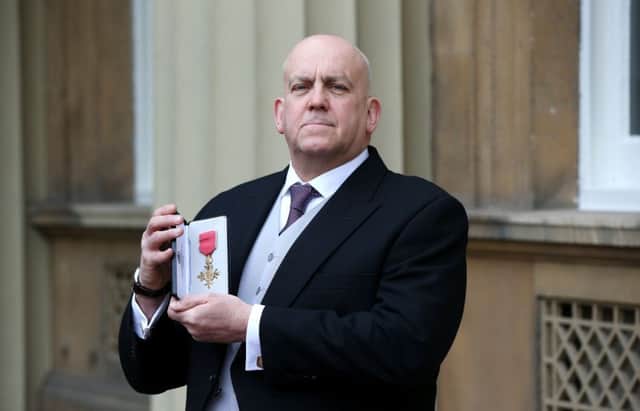 Dr John Godber with his OBE medal following an investiture ceremony at Buckingham Palace