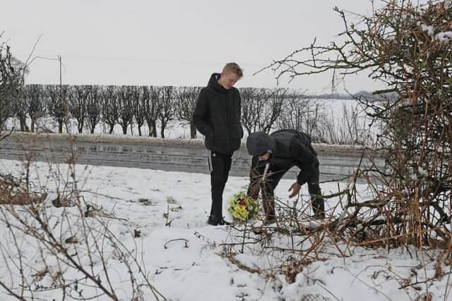 Two youths, aged 17 and 18, place flowers at the scene on the A61 near Thirsk in North Yorkshire where two teenagers died and two children are among seven injured after a three-car crash. Pictures: Owen Humphreys/PA Wire