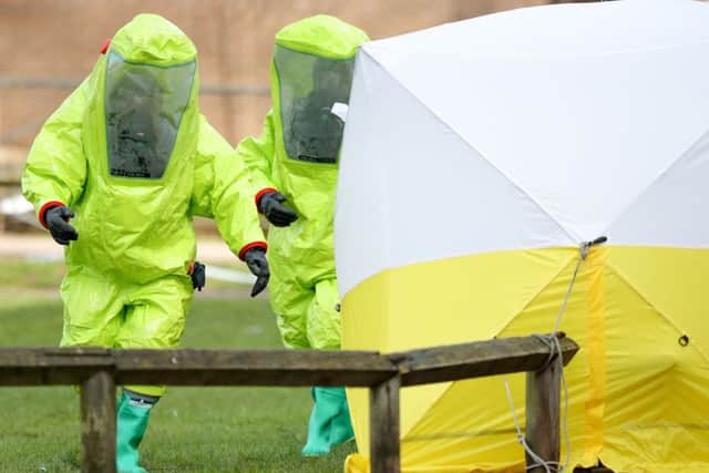 Personnel in hazmat suits work to secure a tent covering a bench in the Maltings shopping centre in Salisbury, where former Russian double agent Sergei Skripal and his daughter Yulia were found critically ill by exposure to a nerve agent.