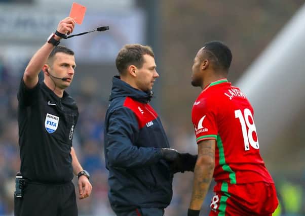 Swansea City's Jordan Ayew (right) is shown the red card by referee Michael Oliver.