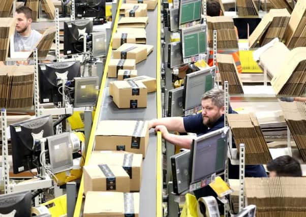 Staff sorting items at an Amazon distribution warehouse.