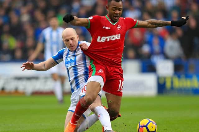 Back in action: Huddersfield Town's Aaron Mooy challenges Swansea City's Jordan Ayew on his comeback.