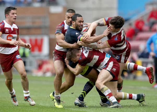 Wakefield Trinity's Bill Tupou is tackled by Wigan Warriors John Bateman (right) Willie Isa (left) and Tom Davies.