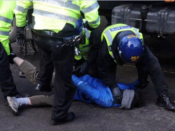 Police in riot gear arrested one protester on Kenwood Road last week after the man had crouched under a cherry-picker for two hours.