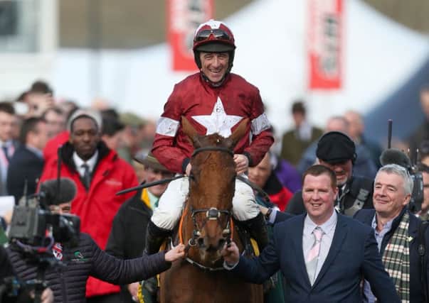 Jockey Davy Russell celebrates winning the Ryanair Chase with horse Balko Des Flos and owner Michael O'Leary, far right, in tow. Picture: Steven Paston/PA