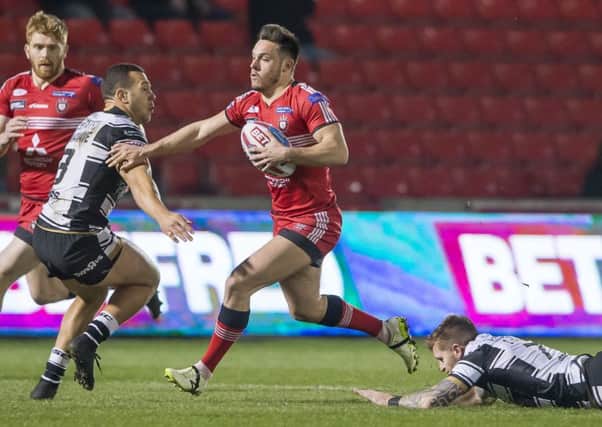 Salford's Niall Evalds fends off Hull FC's Carlos Tuimavave.