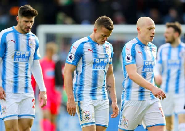 Huddersfield Town's Jonathan Hogg (centre) and Huddersfield Town's Aaron Mooy (right) leave the pitch dejected.