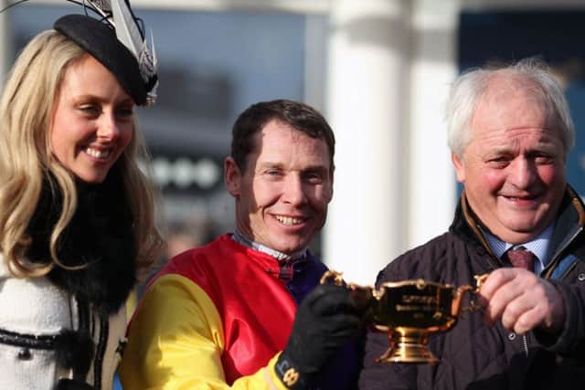 Jockey Richard Johnson celebrates with the trophy alongside trainer Colin Tizzard (right) and wife Fiona after winning the Timico Cheltenham Gold Cup Chase.