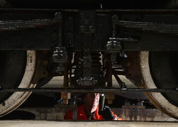 OILING THE WHEELS: Maintenance engineer Ray Thornton working on a carriage in Wensleydale Railways new engine shed at Leeming Bar Station. PIC: Bruce Rollinson