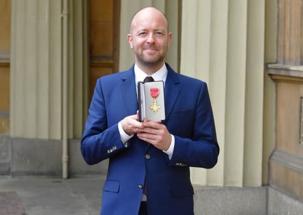 Theatre director John Tiffany holds his OBE following an investiture ceremony at Buckingham Palace. Picture by John Stillwell/PA Wire.