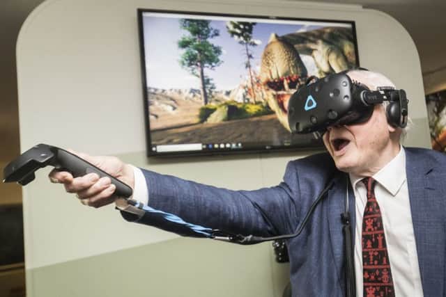 Sir David Attenborough tries out a virtual reality headset as he officially opens Yorkshire's Jurassic World at the Yorkshire Museum in York. PA
