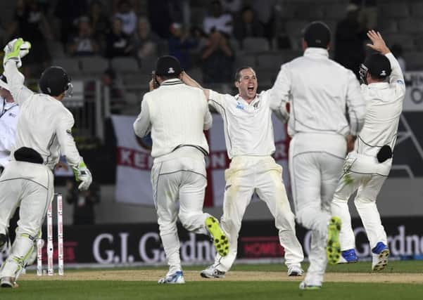 New Zealand bowler Todd Astle raises his arms and celebrates with his team-mates after the dismissal of Englands James Anderson saw the hosts win the first Test by an innings and 49 runs in Auckland (Picture: Ross Setford/AP).