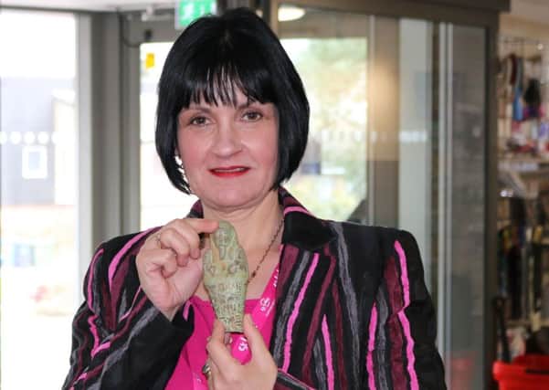 Charity shop manager Lana Beech holds up the shabti which was found among a box of donations left at the St Luke's Hospice store in Sheffield anonymously.