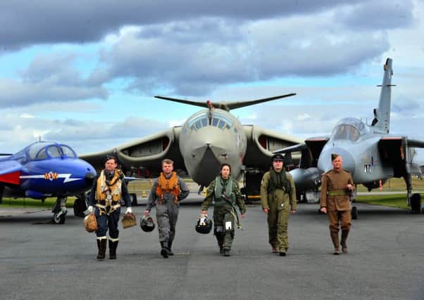 Saluting  the RAF centenary at the Yorkshire air Musum at Elvington near York,  with  different aircraft and uniforms through the  ages, l to r... Andy Stamp  WW2 , Charles Hancock 1950/60's, Sandrine Bauchet (present day,) Yoan Martin  1980's  and Gary Hancock WW1 , with in the  background from left ,  a T7 Hawker Hunter trainer 1950's,  Handley page Victor Bomber 1960's and a Prototype Tornador GR4  present day.