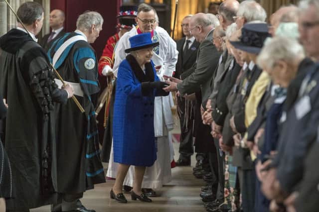 The Queen distributes the traditional Maundy money during the Royal Maundy service  at St George's Chapel in Windsor.