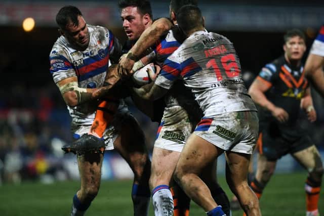 Castleford's Grant Millington is wrapped up by Wakefield's defence. (Picture: Jonathan Gawthorpe)