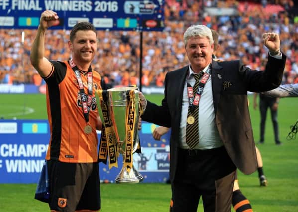 Happy day: Hull City's Alex Bruce with manager and father Steve with the trophy after winning the Championship play-off final at Wembley against Sheffield Wednesday.