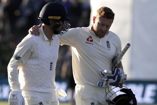 England's Jonny Bairstow, right, embraces team-mate Jack Leach as they leave the field at the close of play on day one of the second cricket test against New Zealand at Hagley Oval in Christchurch, New Zealand. (AP Photo/Mark Baker)