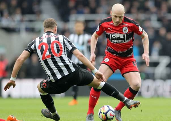 JKept out: Newcastle United's Florian Lejeune and Huddersfield Town's Aaron Mooy battle for the ball at St James' Park.