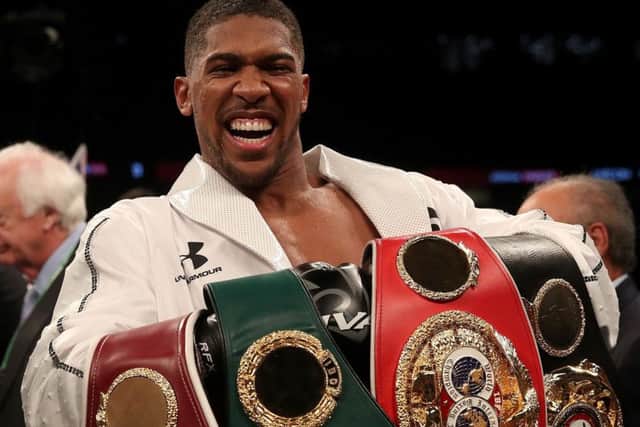 Buckled up: Anthony Joshua celebrates with his belts.