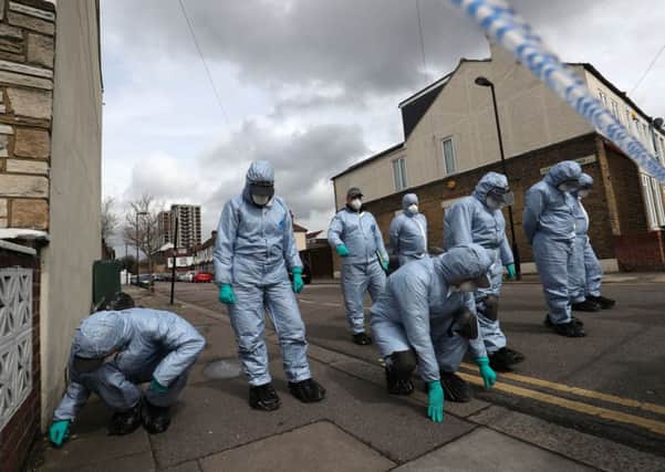 Forensics officers investigate the scene in London where a teenage girl was shot dead on Monday night.