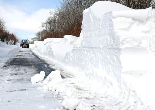 A farmer in a tractor helps to clear the snow. Photo credit: Andrew Matthews/PA Wire