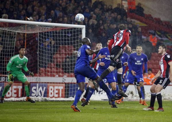 Injured: Richard Stearman heading just over against Cardiff.