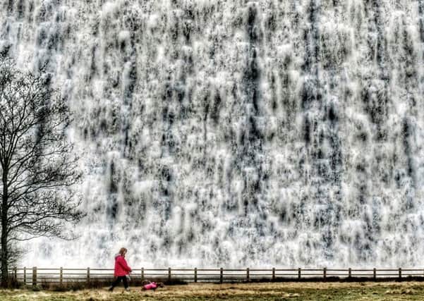 A great torrent of meltwater cascades over the dam wall at Derwent Dam.