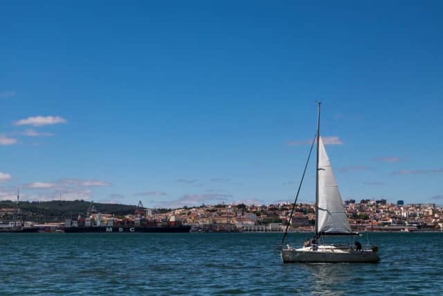 Downtown Lisbon and sailing ships viewed from the south bank of the river Tagus.