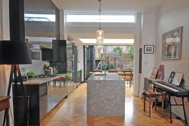 The open plan living kitchen with extension and bifold doors leading to the garden. The kitchen units are from Wren and the isalnd is granite with Habitat lights above