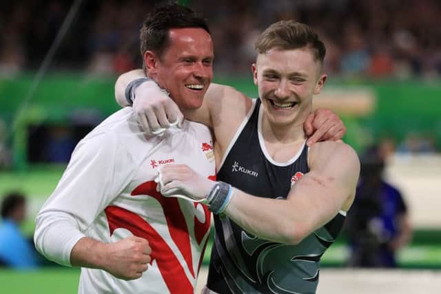 England's Nile Wilson celebrates winning a gold medal in the Men's Individual All-Round Final with coach Ben Collie. Picture: Mike Egerton/PA.