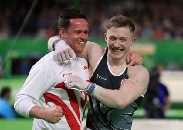 England's Nile Wilson celebrates winning a gold medal in the Men's Individual All-Round Final with coach Ben Collie. Picture: Mike Egerton/PA.