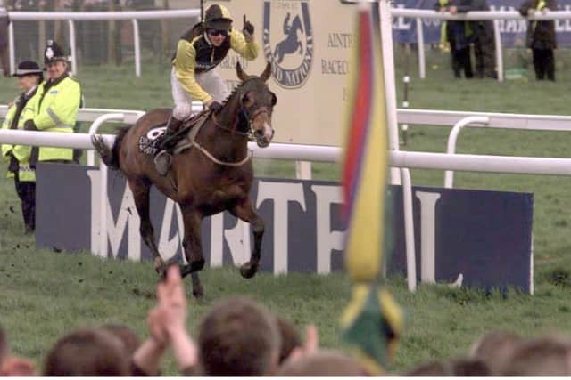 Earth Summit, ridden by Carl Llewellyn, crosses the line to win the 1998 Martell Grand National (Picture: Adam Butler/PA).