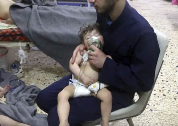 This image made from video released by the Syrian Civil Defense White Helmets, which has been authenticated based on its contents and other AP reporting, shows a medical worker giving toddlers oxygen through respirators following an alleged poison gas attack in the opposition-held town of Douma, in eastern Ghouta, near Damascus, Syria.