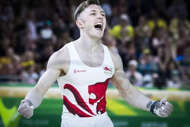 England's Nile Wilson (gold) celebrates following his routine on the Men's Horizontal Bar